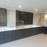 A room with black cabinets and white walls.