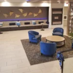 A lobby with blue chairs and tables in it