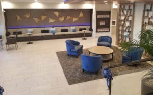 A lobby with blue chairs and tables in it