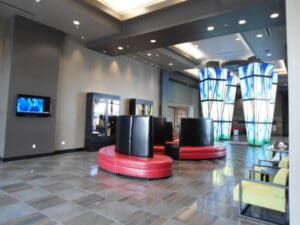A lobby with red chairs and black tables