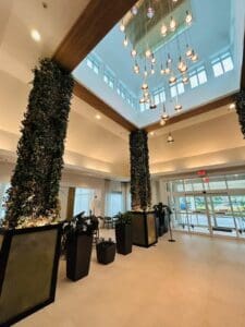 A lobby with a large ceiling and lots of plants.