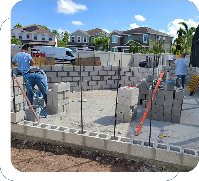 A group of people building a house with concrete blocks.