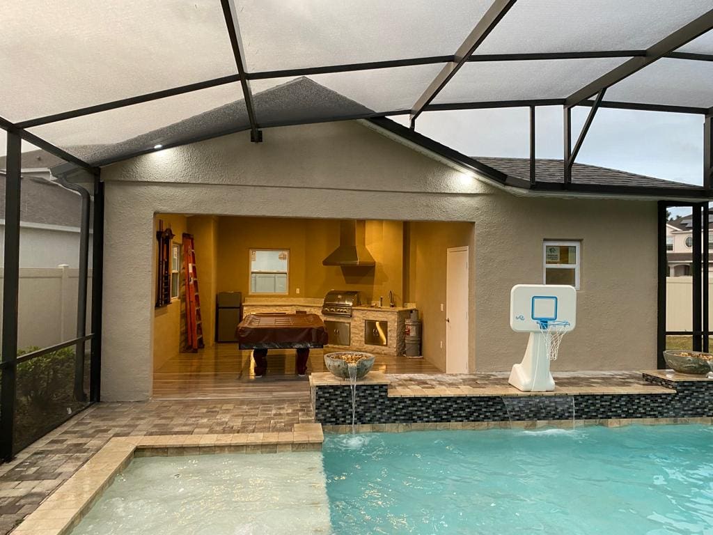 Here's an alt tag for the image: Outdoor pool, cabana, and basketball hoop.